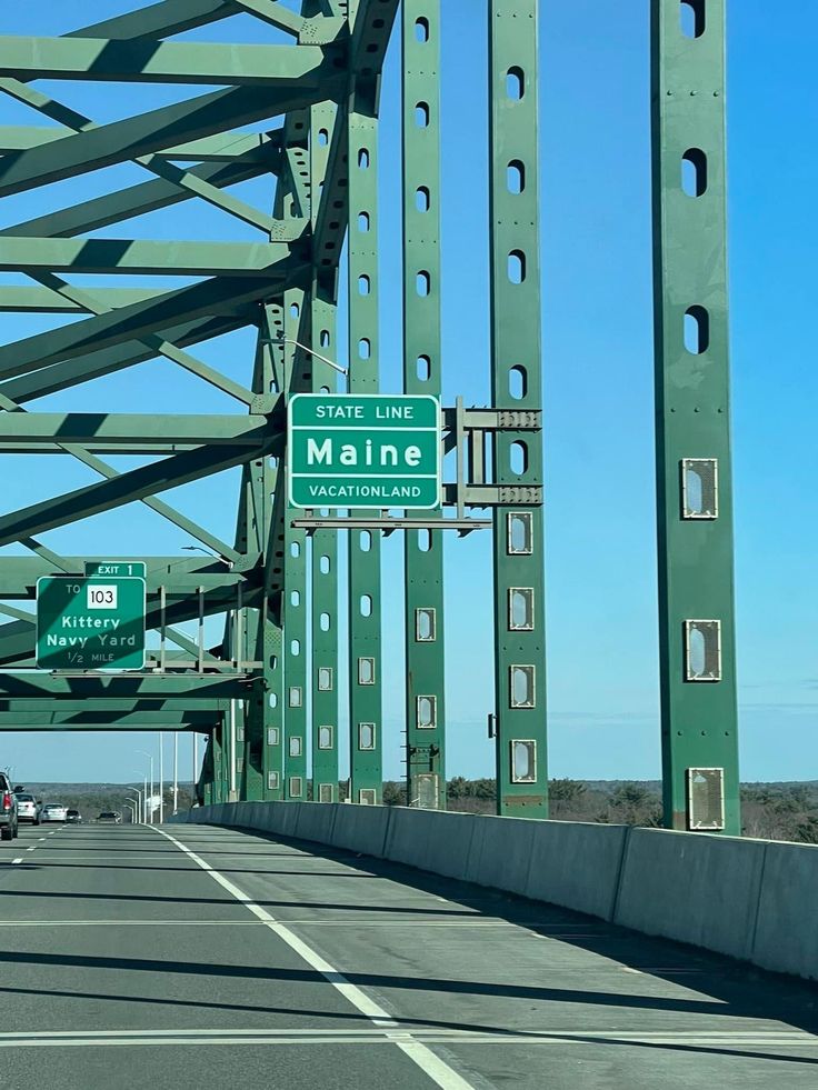 the highway sign is clearly visible for all to see on this bridge over looking the ocean