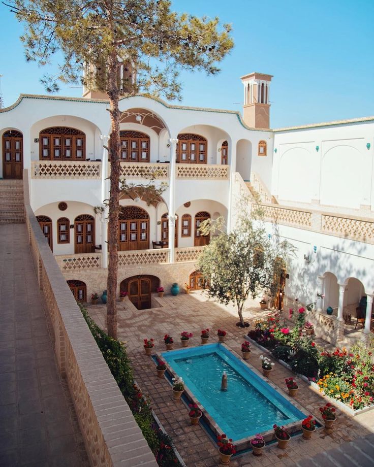 an outdoor swimming pool in front of a large white building