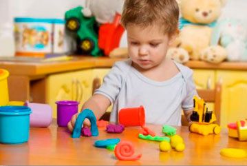 a young child playing with toys at a table