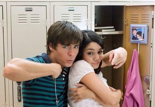 a young man and woman taking a selfie in front of a mirror with their arms around each other