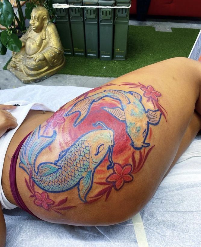 a woman laying on top of a bed with a tattoo on her stomach and legs