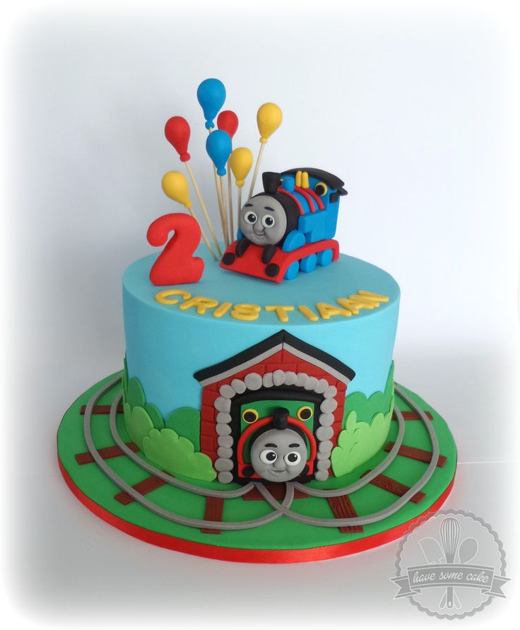 a thomas the train birthday cake with balloons on it's top and number two