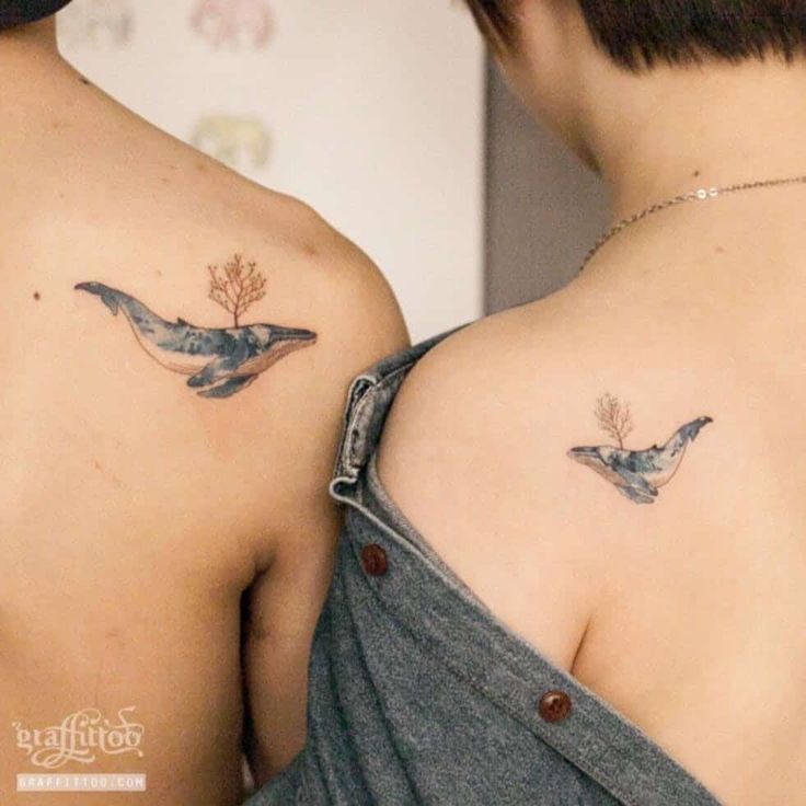 two women with matching tattoos on their backs