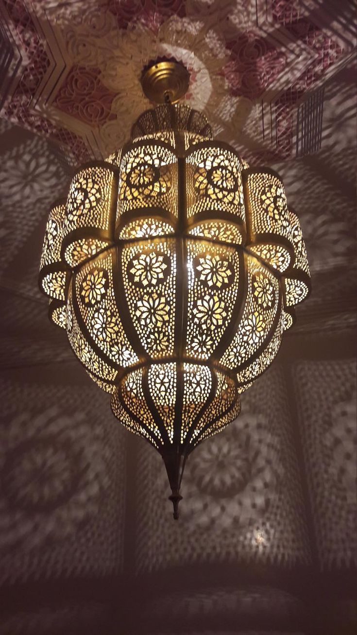 an ornate chandelier hanging from the ceiling in a room with patterned walls and ceilings