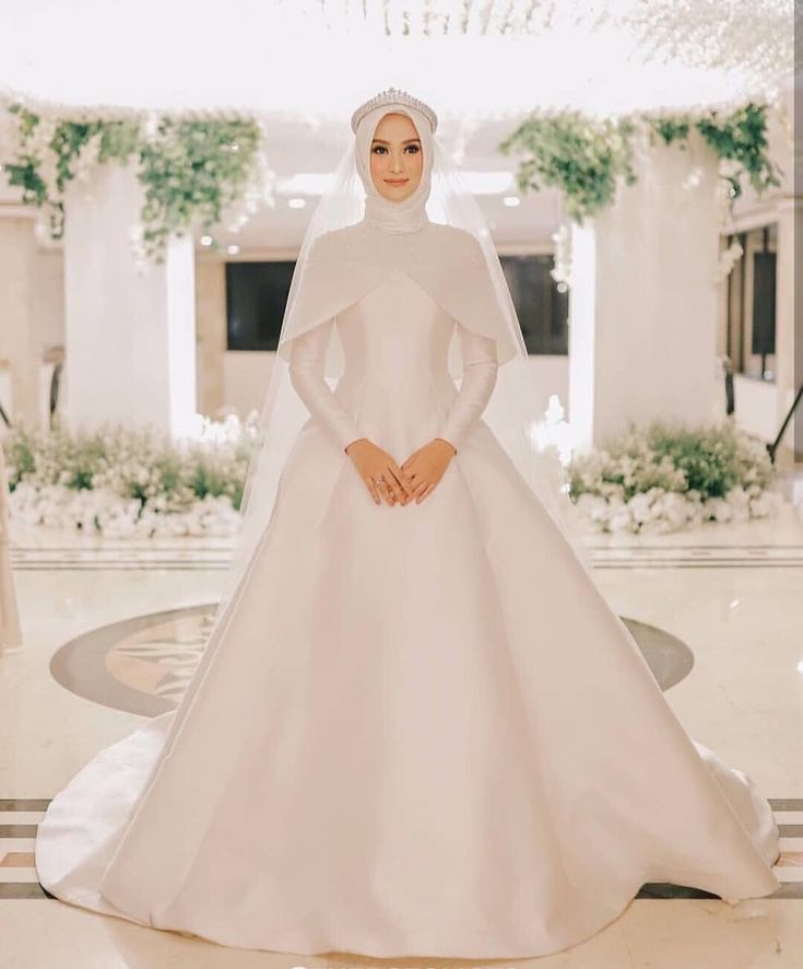 a woman in a white wedding dress standing on the floor