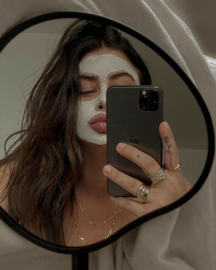 a woman is taking a selfie in the mirror with her face painted like a cat