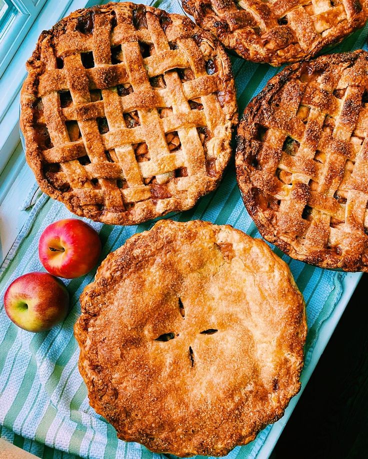 four apple pies sitting on top of a blue towel