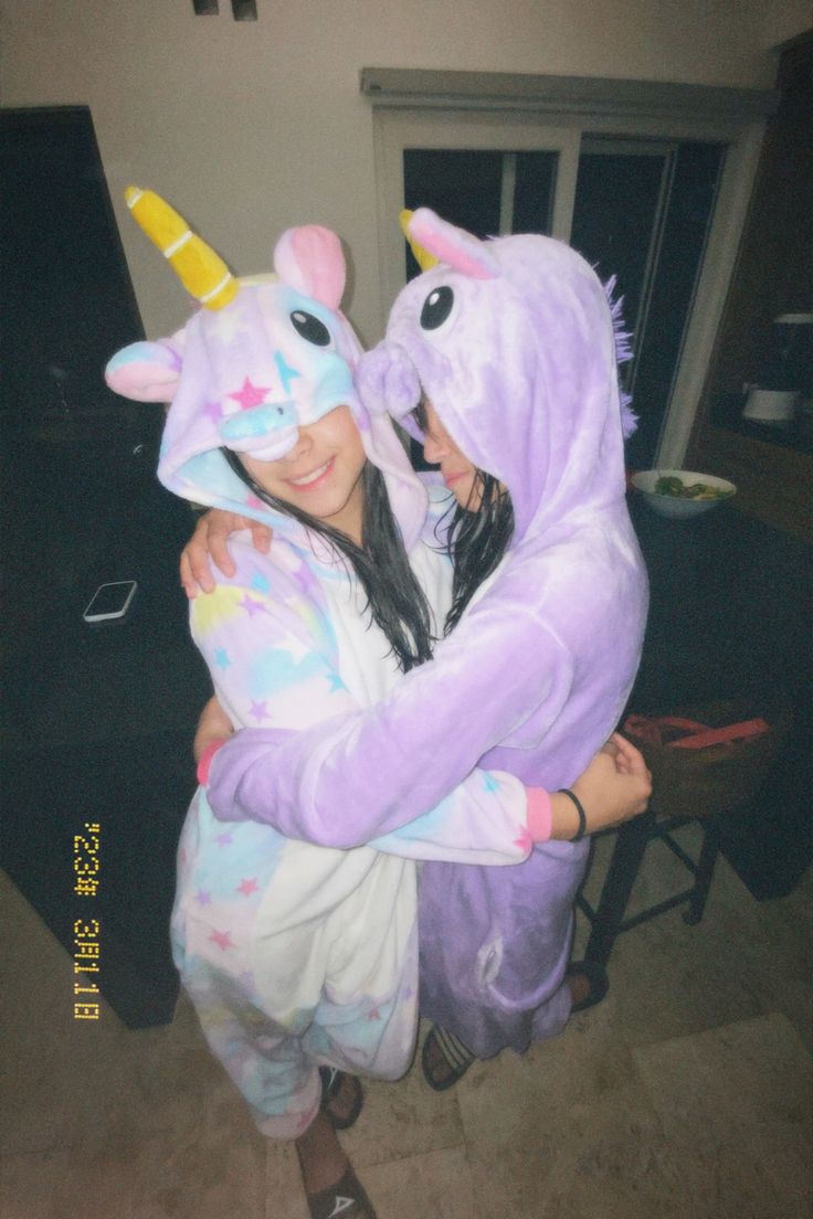 two girls in unicorn costumes hugging each other