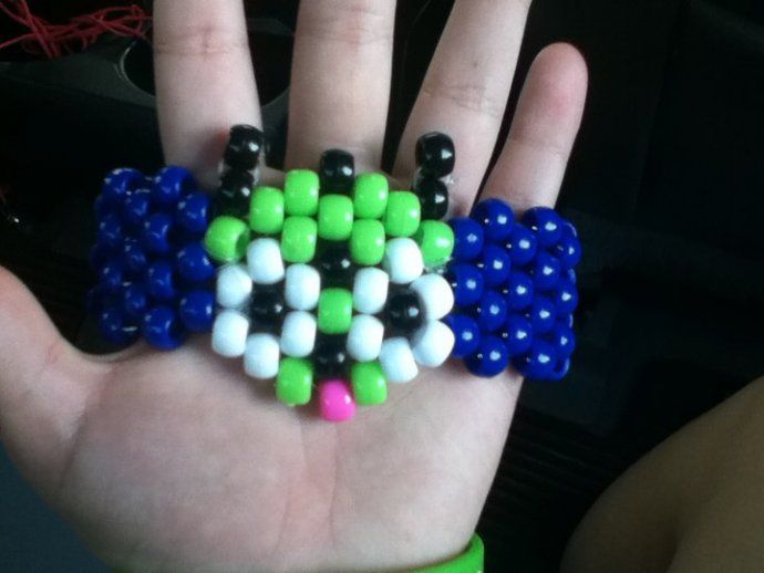 a hand holding several different colored beads on it