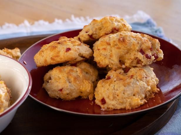 some biscuits are on a red plate next to a white bowl