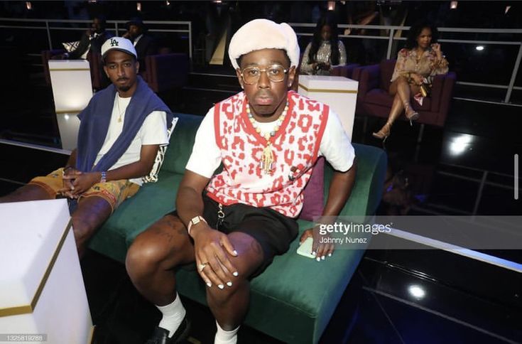 two men sitting in chairs at an event