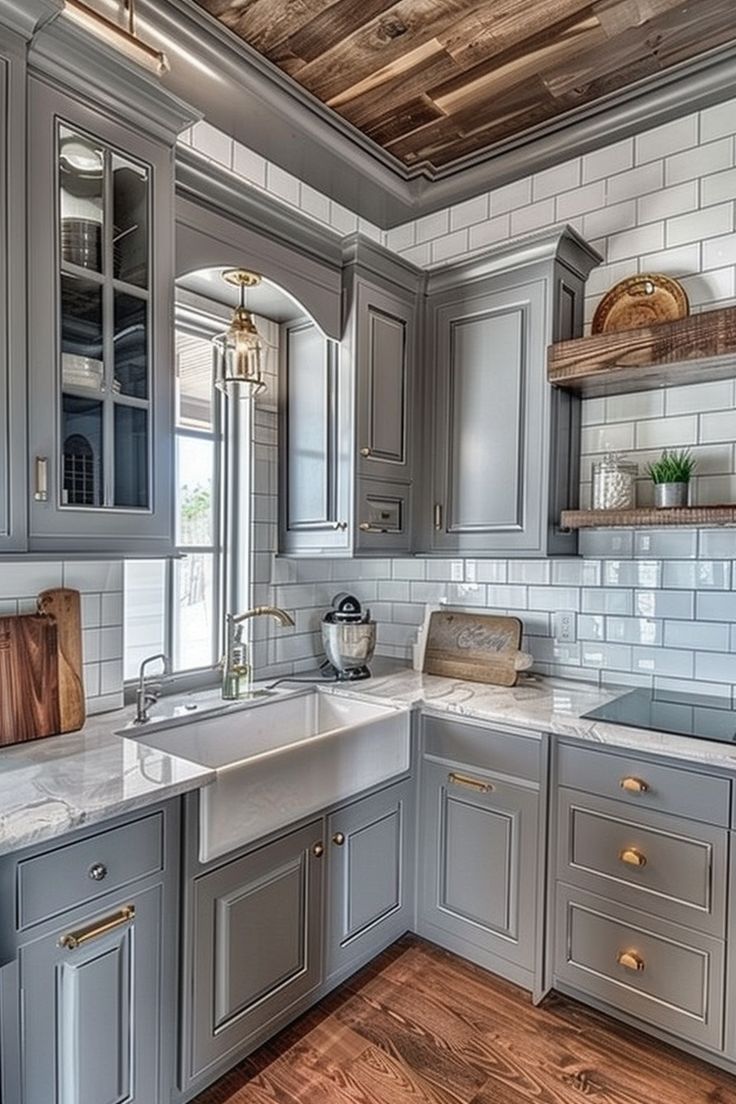 a kitchen with gray cabinets and white counter tops, wood flooring and wooden ceiling