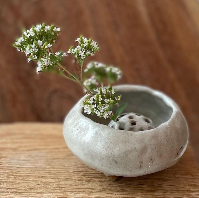 a small white vase with some flowers in it