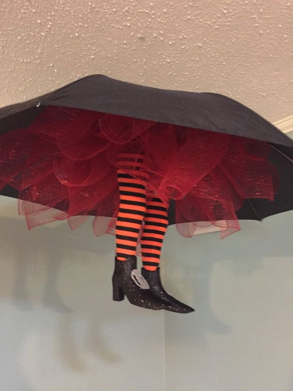 a black umbrella with red and orange striped stockings hanging from it's side, attached to the ceiling