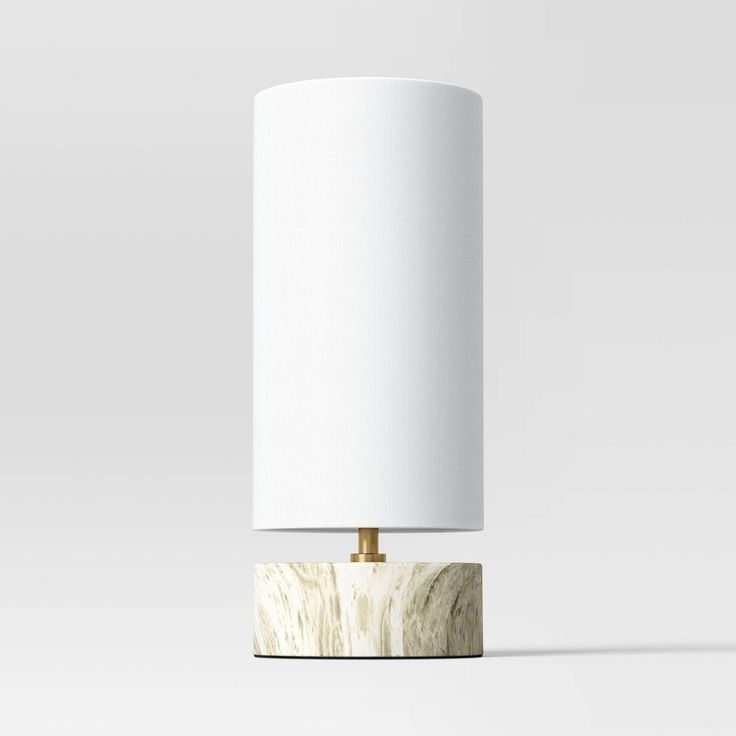 a lamp that is on top of a wooden base with a white shade over it