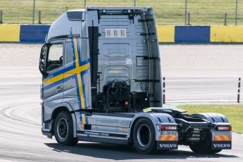 a large semi truck driving down a race track