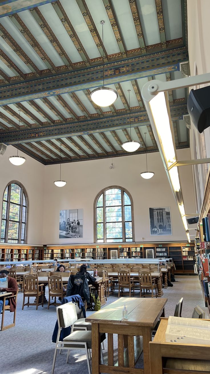 the inside of a library with tables and chairs