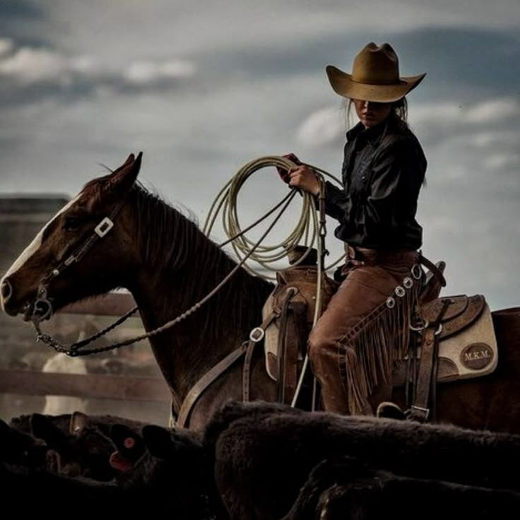 a man in cowboy attire riding on the back of a brown horse