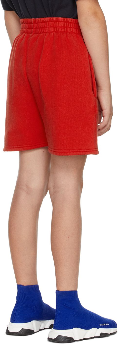 Cotton fleece shorts in red featuring logo printed in white at front. · Two-pocket styling · Elasticized waistband · Machine wash Model measures 51” / 129.5 cm tall and wears size 8. Supplier color: Bright red Size: child's height 2: 35.75 / 91 cm 4: 41.25 / 105 cm 6: 46.75 / 118.5 cm 8: 52.25 / 132.5 cm 10: 55.35 / 140.5 cm Red Shorts With Side Pockets, Red Short Bottoms For Streetwear, Red Short Length Bottoms For Streetwear, Red Streetwear Shorts, Red Cotton Sporty Bottoms, Sporty Red Shorts For Loungewear, Sporty Red Cotton Shorts, Red Shorts With Elastic Waistband For Streetwear, Sporty Red Shorts With Pockets