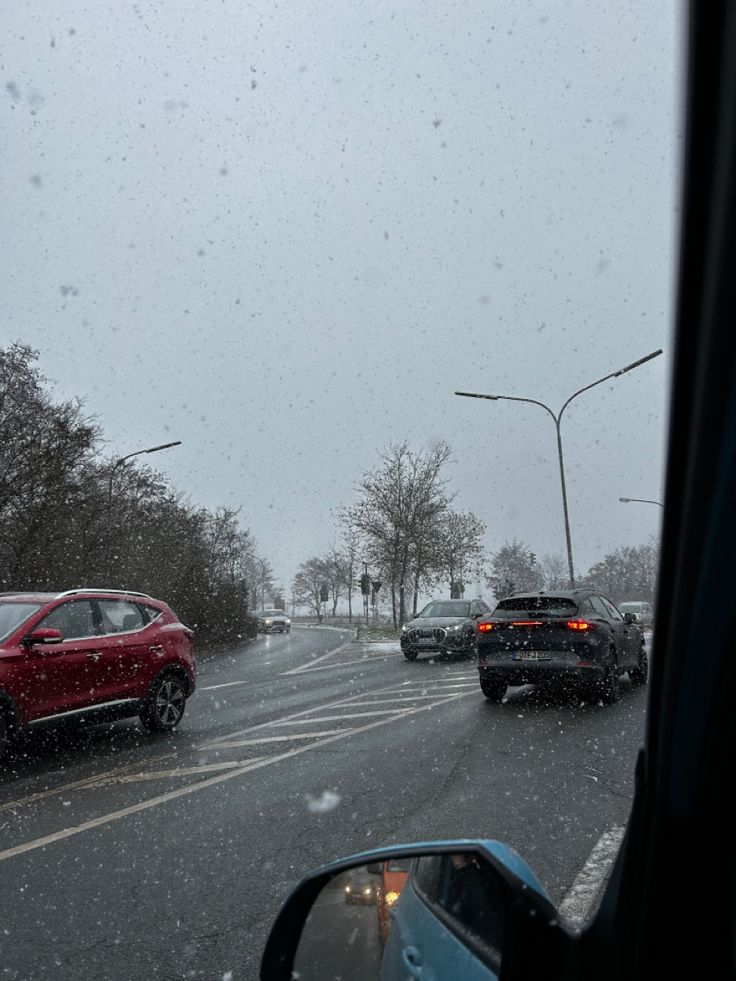 cars driving down the road in heavy snow