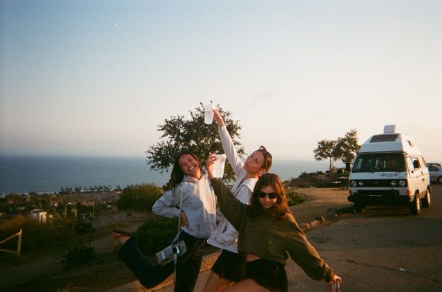 three young women posing for the camera with their arms in the air