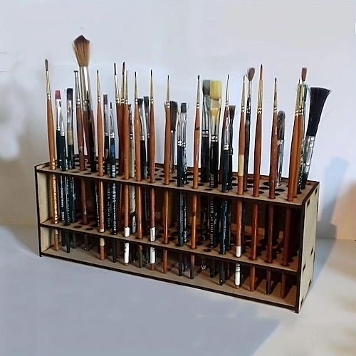 a wooden display case filled with lots of paintbrushes on top of a table