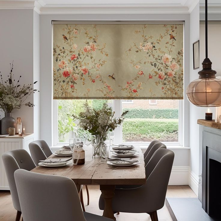 a dining room table and chairs in front of a window with flowers on the blinds