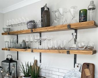 the shelves are filled with wine glasses and other glassware on top of each shelf