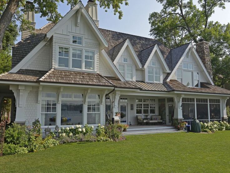 a large white house with lots of windows on the front and side of it's roof