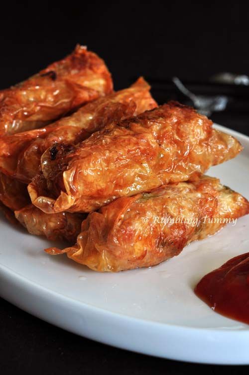 some food is sitting on a white plate with ketchup and sauce in front of it