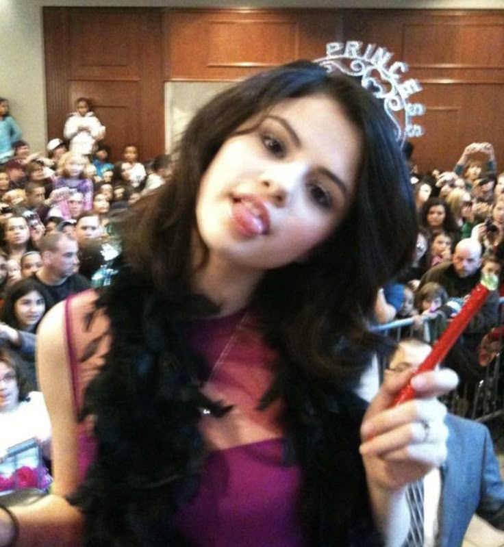 a woman holding a red toothbrush in front of a crowd