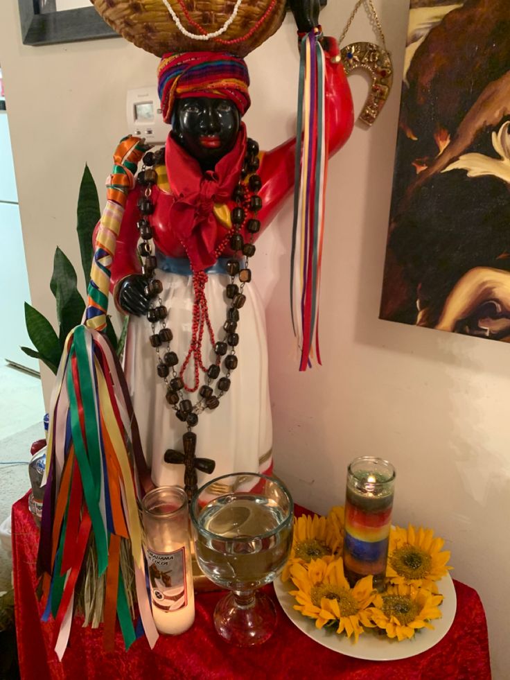 a table that has some items on it and a vase with flowers in front of it