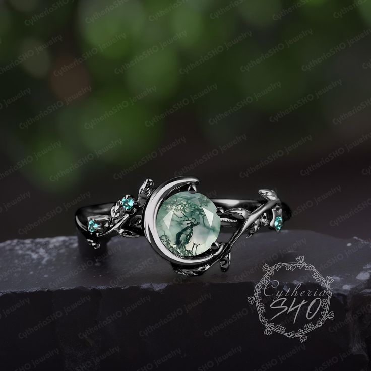 a ring with an image of a woman's face and green crystals on it