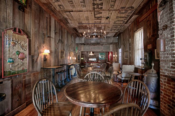 an old fashioned dining room with wooden tables and chairs