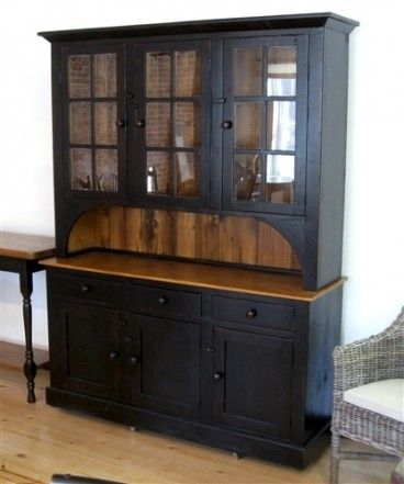 a black china cabinet sitting on top of a hard wood floor