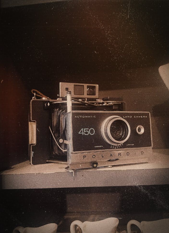 an old camera sitting on top of a shelf