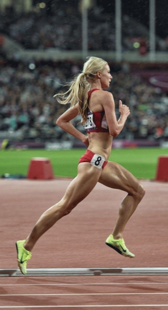 a woman running on a track in a stadium