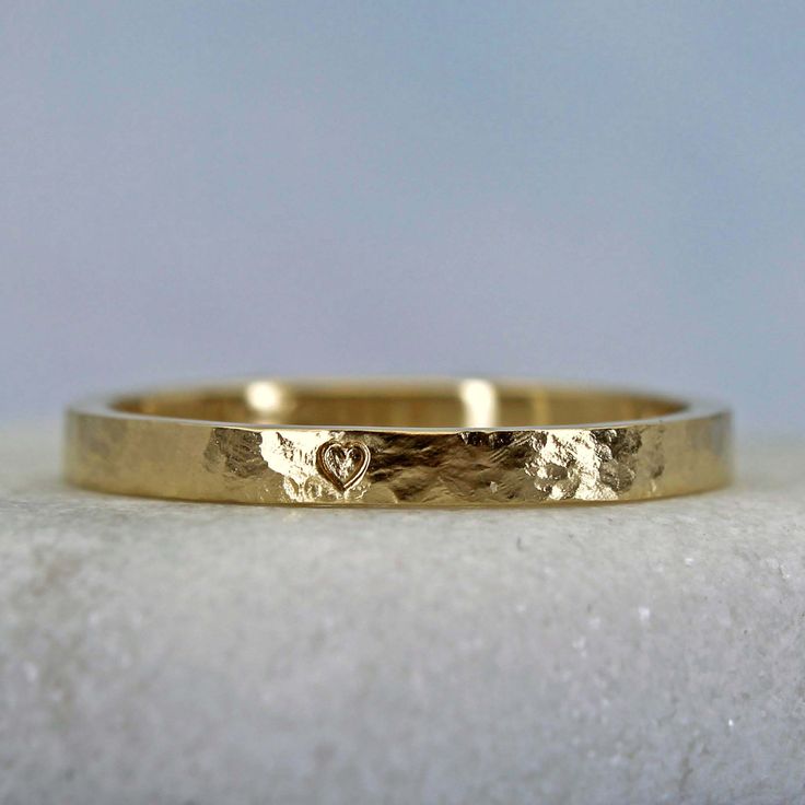 This personalized gold stacking ring has a rustic distressed finish that gives it a gentle timeworn vibe. The distressed finish gives the ring a subtle shine. Your inscription can go on the outside or the inside of this sweet little ring. Details Made from solid 14k yellow gold. 2mm wide and about 1.2mm thick. Rustic hammered finish Price includes an inscription of up to 14 characters.Available are uppercase letters A-Z, numbers 0-9, &, . , -, and a little heart symbol Important! The ring will b Gold Hammered Stackable Rings For Promise, 14k Gold Hammered Stackable Promise Rings, Gold Hammered Engraved Promise Ring, Gold Hammered Engraved Ring For Promise, Gold Hammered Stackable Wedding Rings, Gold Hammered Stackable Rings For Anniversary, Anniversary Yellow Gold Hammered Stackable Rings, Gold Hammered Stackable Rings For Wedding, Dainty Hammered Stackable Rings As Gift