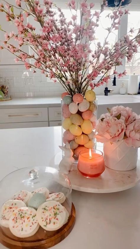 a table topped with cookies and flowers next to a candle