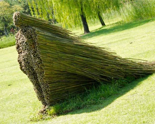 a sculpture made out of sticks in the grass