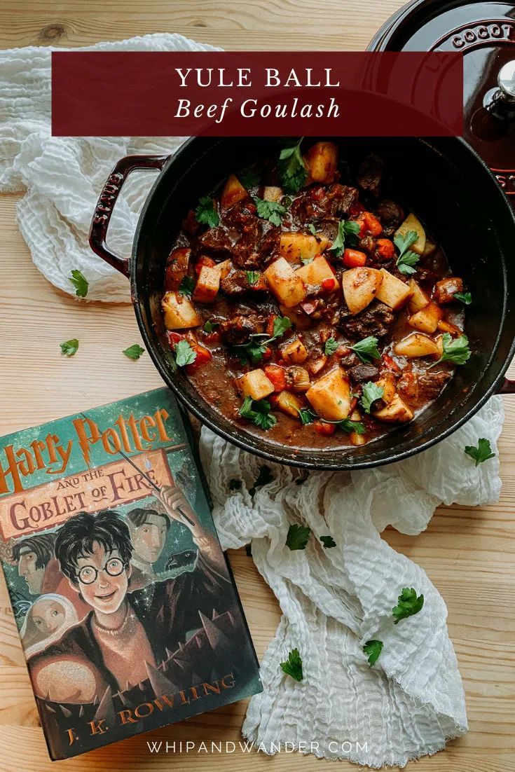 harry potter cookbook and stew in a pan on a wooden table next to a book