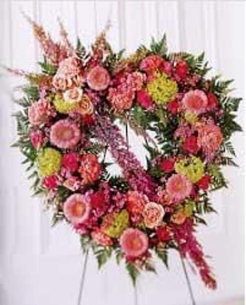 a floral wreath is displayed in front of a white wall