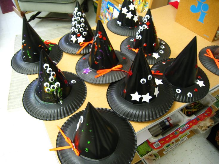 a table topped with paper plates covered in black witches hats and stars on top of them