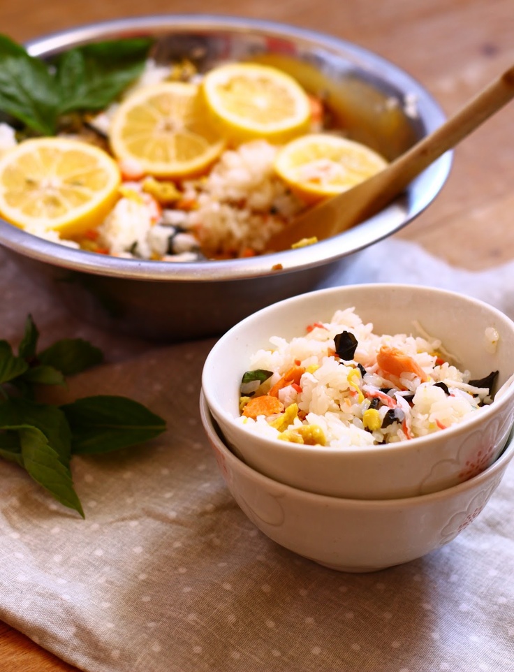 two bowls filled with rice, lemons and other food on top of a table