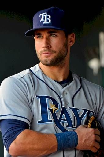 a close up of a baseball player wearing a uniform and holding a glove in his hand