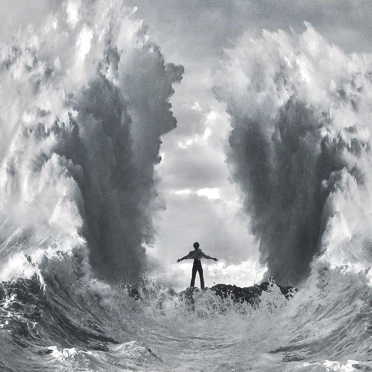 a man standing on top of a surfboard in the middle of a large wave