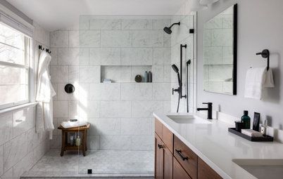 a bathroom with a walk in shower sitting next to a sink and a mirror on the wall