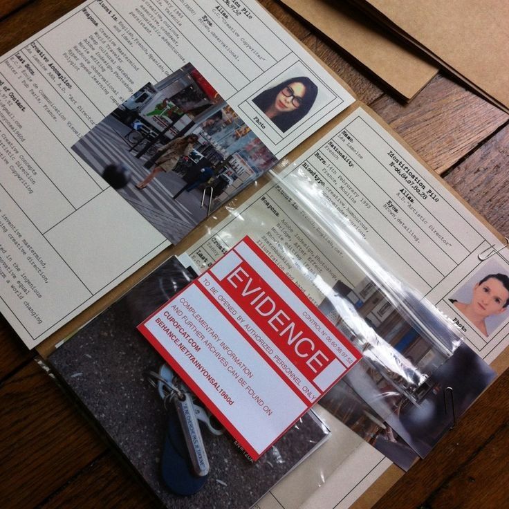 two pamphlets on top of a wooden table next to a pair of scissors and a pen