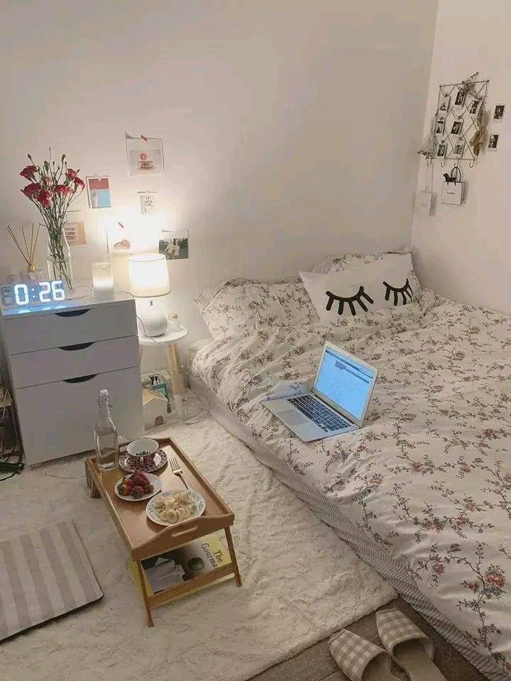 a laptop computer sitting on top of a bed next to a night stand and nightstand