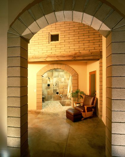 an archway leading into a bathroom with a shower and chair in the middle of it